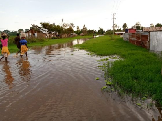 Women walk on flood waters.