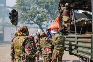 Police camouflage and protective gear officers detain a protester and lift him into a truck during a protest in Kenya’s capital, Nairobi.